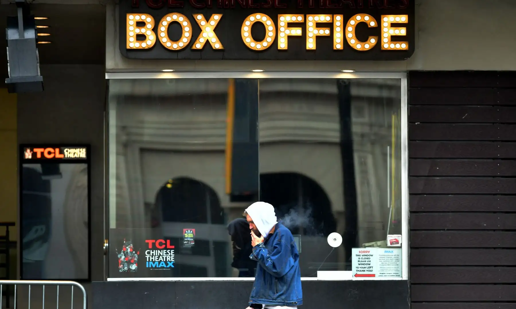 Un hombre pasa frente a una taquilla cerrada a lo largo de Hollywood Boulevard en Estados Unidos. Foto:AFP