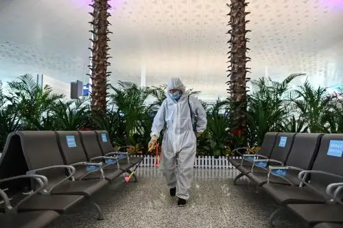 Un trabajador que usa equipo de protección rocía desinfectante en el aeropuerto de Tianhe después de su reapertura hoy, en Wuhan. Foto: AFP