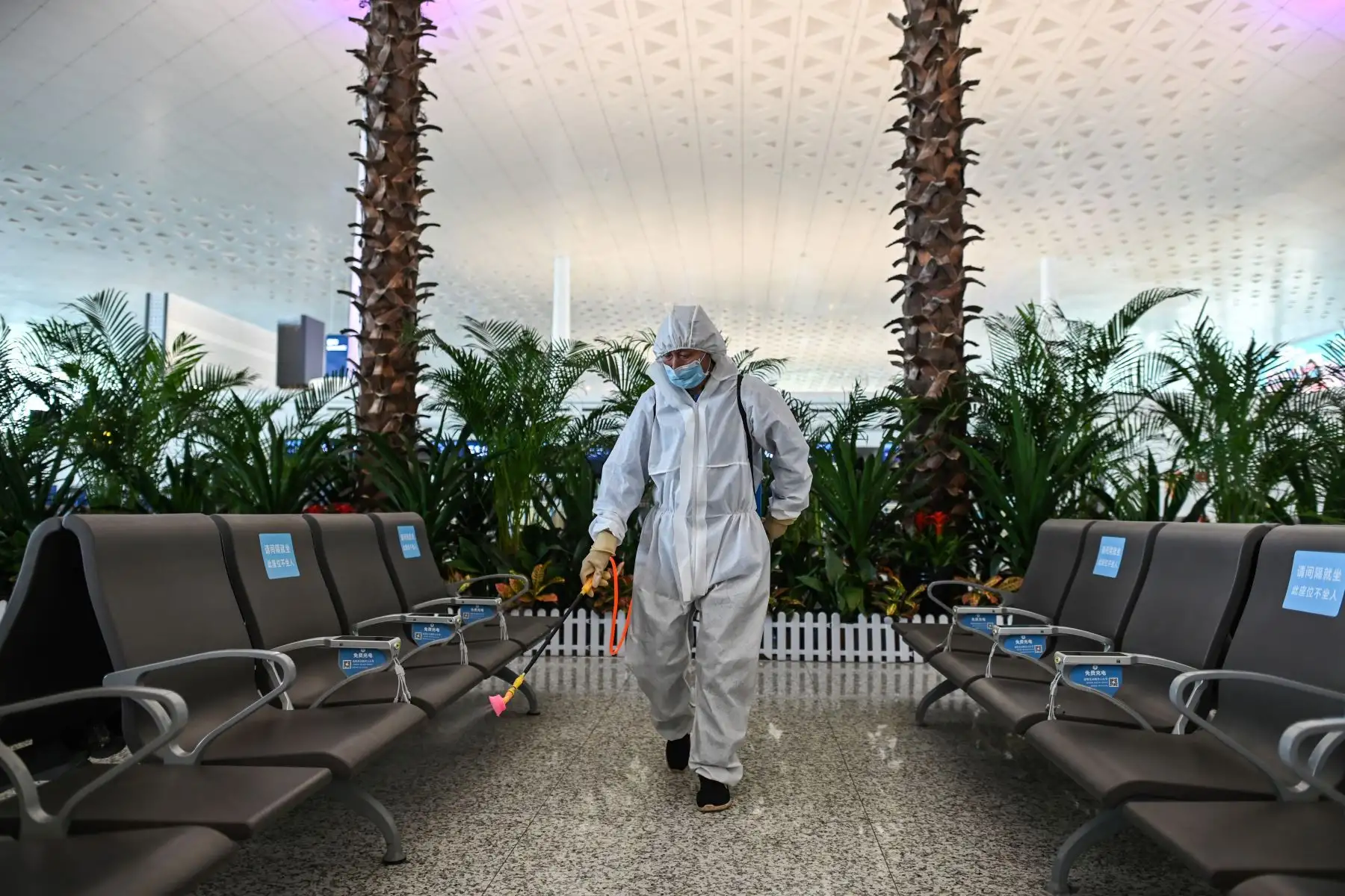 Un trabajador que usa equipo de protección rocía desinfectante en el aeropuerto de Tianhe después de su reapertura hoy, en Wuhan. Foto: AFP