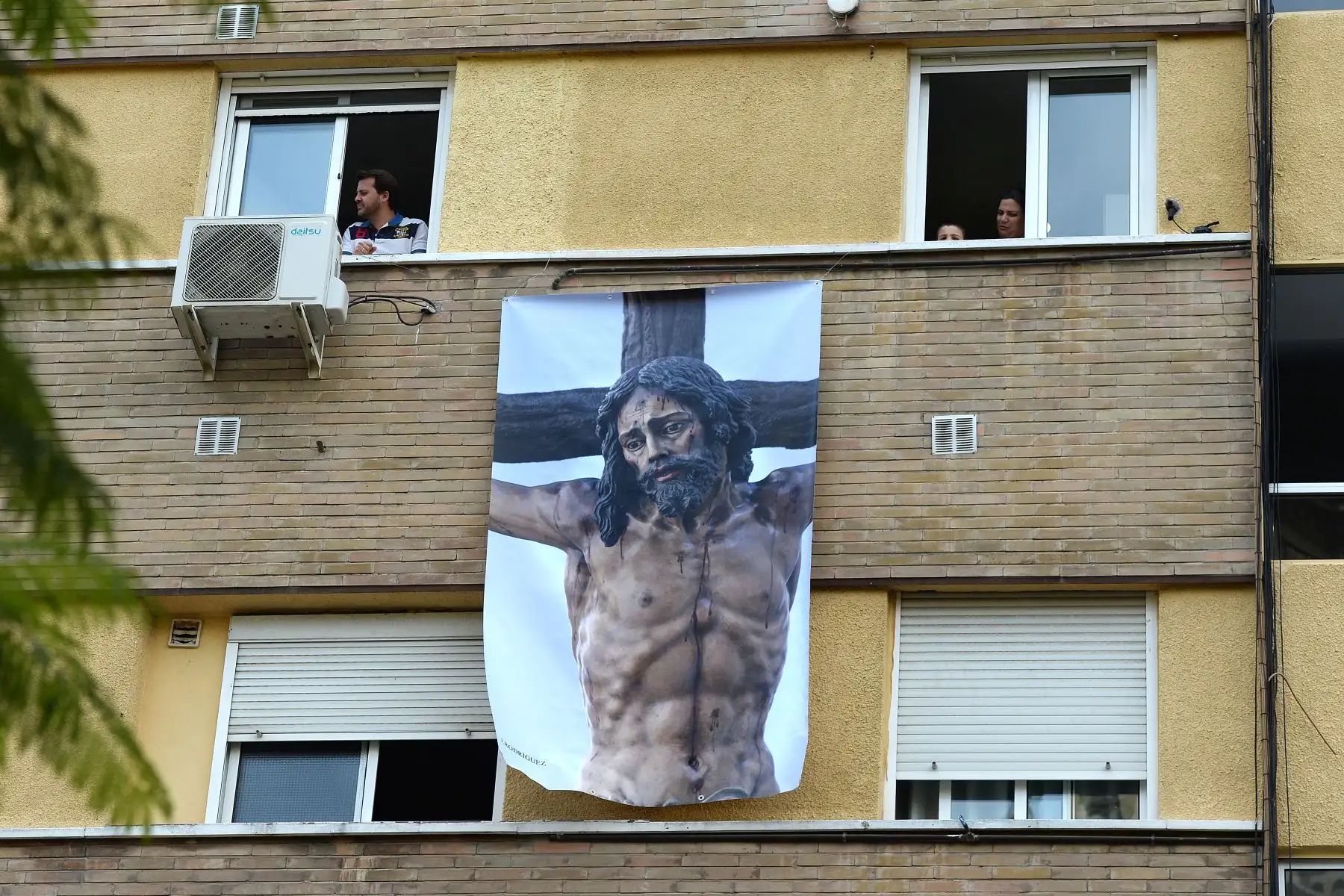 Un cartel que representa una imagen religiosa de Jesucristo cuelga en una fachada  en Sevilla, donde se cancelaron las procesiones de Pascua durante un cierre nacional para evitar la propagación de la enfermedad COVID-16. 
Foto: AFP