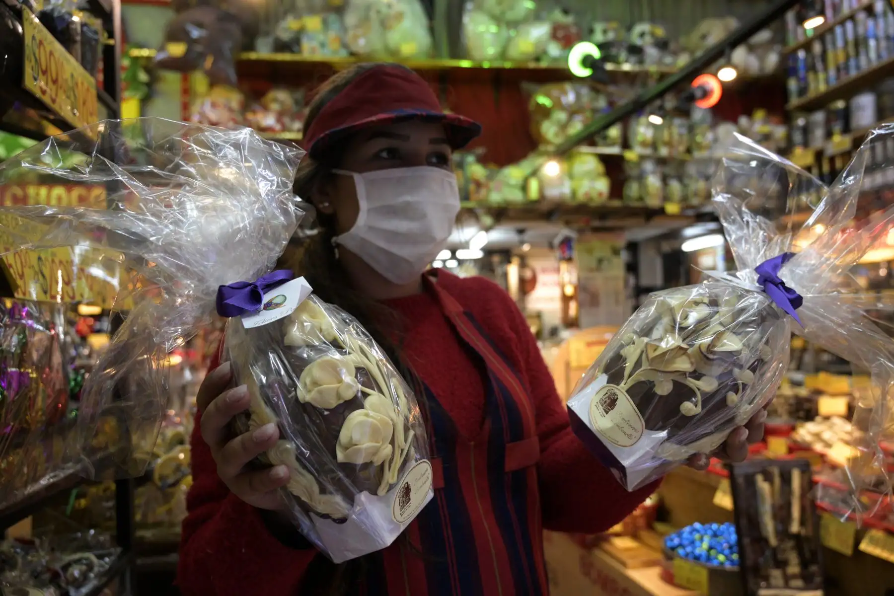 Una trabajadora con una máscara facial ofrece huevos de Pascua a clientes en el centro de Buenos Aires durante la Semana Santa.
Foto: AFP