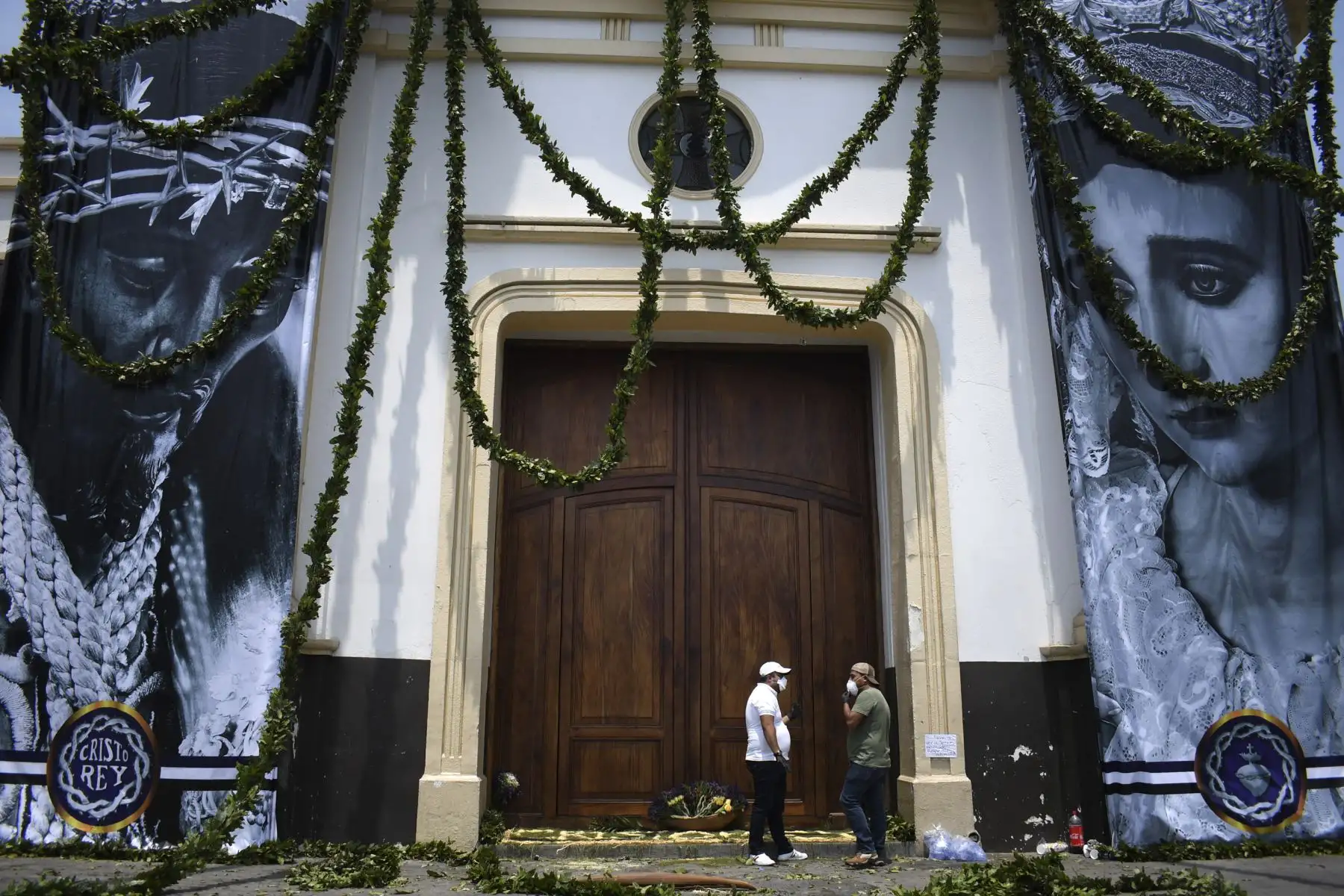 Los miembros de la hermandad Cristo Rey usan máscaras faciales contra la propagación del nuevo coronavirus fuera de la Iglesia de la Candelaria, ,  que permanece cerrada durante la Semana Santa en Guatemala.
Foto: AFP
