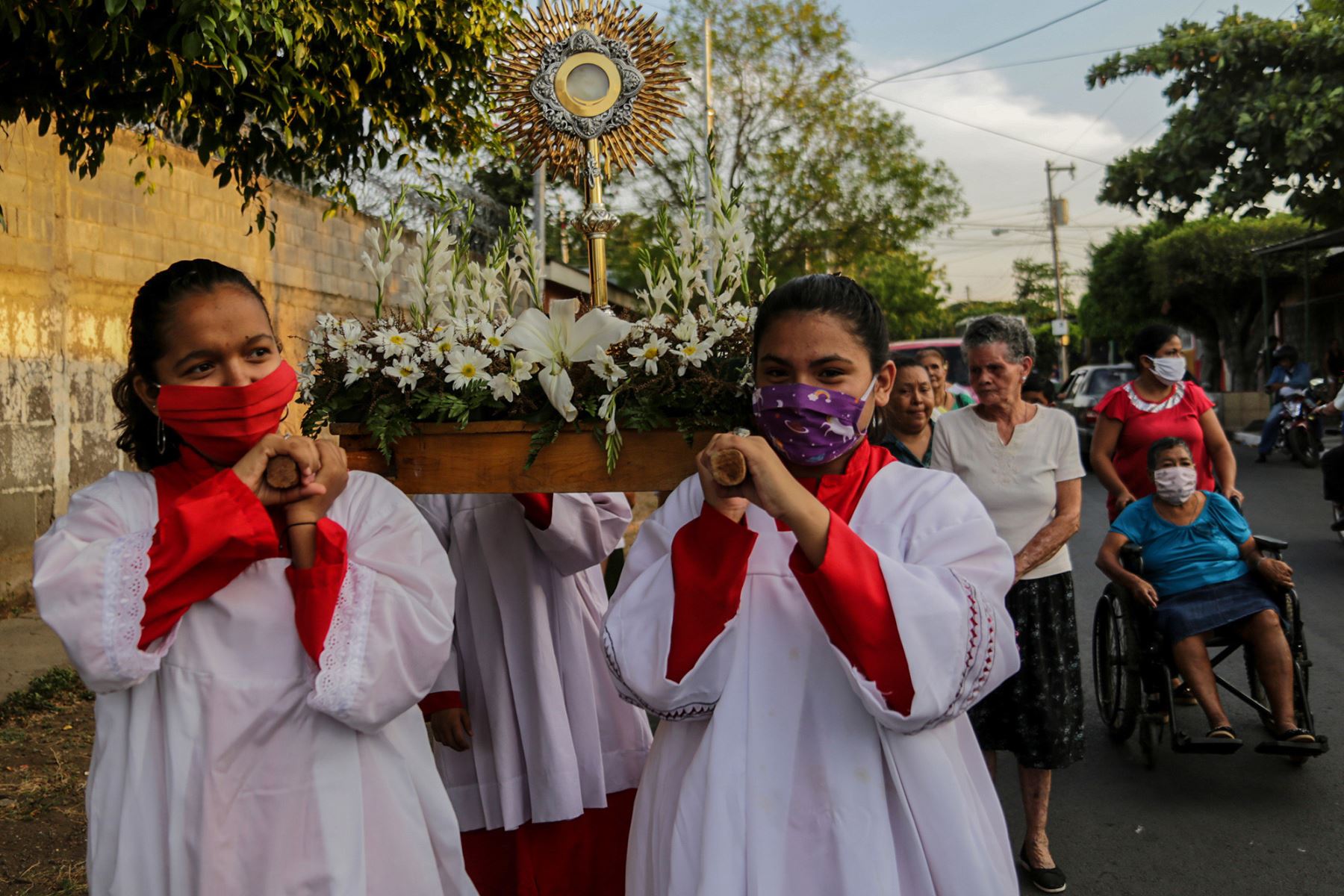 Fieles católicos en la procesión del Camino de la Cruz Penitencial haciendo estaciones en los hogares de personas enfermas, en Managua.
Foto: AFP