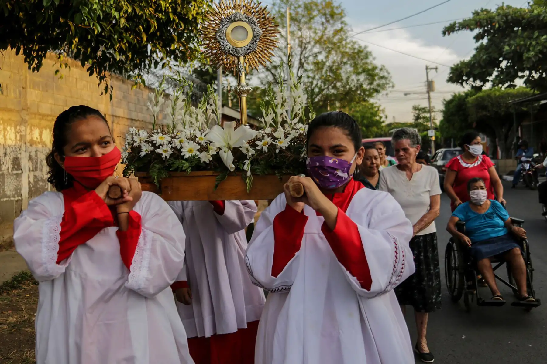Fieles católicos en la procesión del Camino de la Cruz Penitencial haciendo estaciones en los hogares de personas enfermas, en Managua.
Foto: AFP