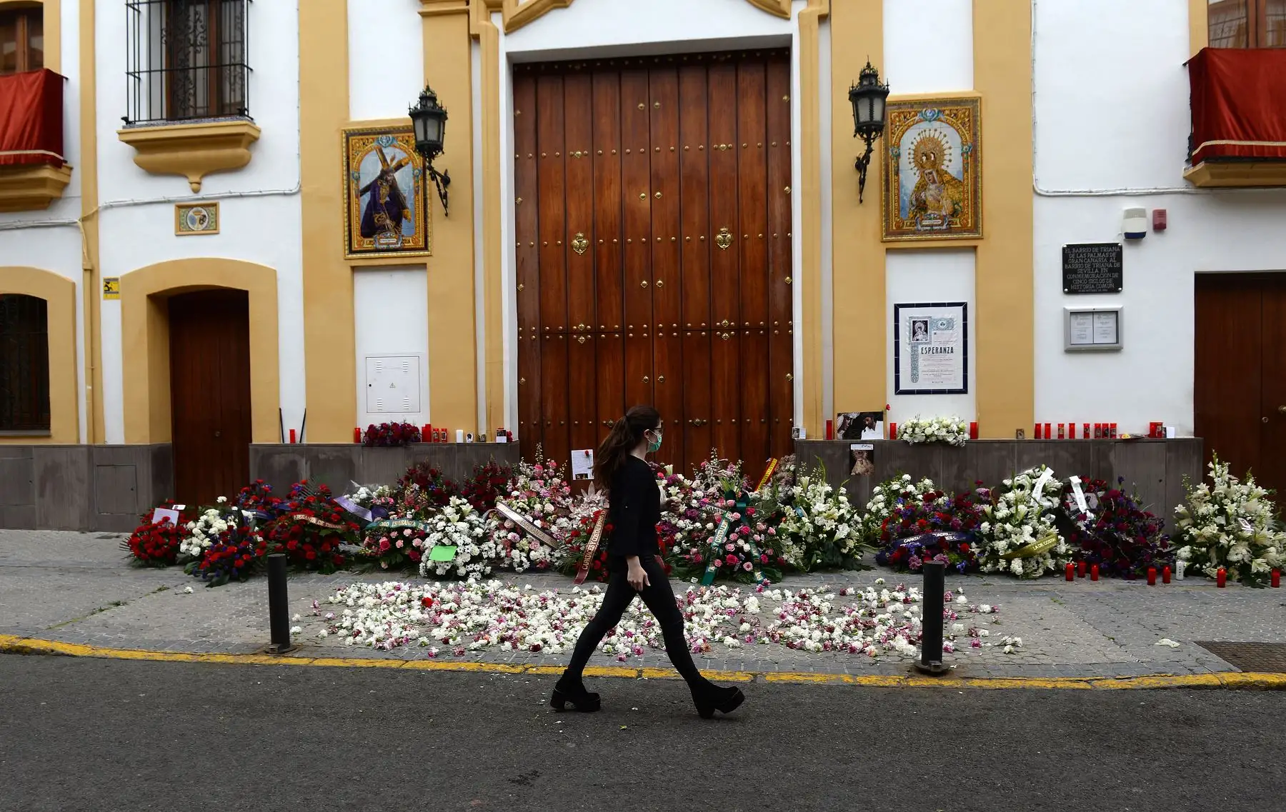 Una mujer camina por la iglesia La Esperanza de Triana en Sevilla. Iglesia luce adornada con flores dejadas por los fieles. Foto: AFP
