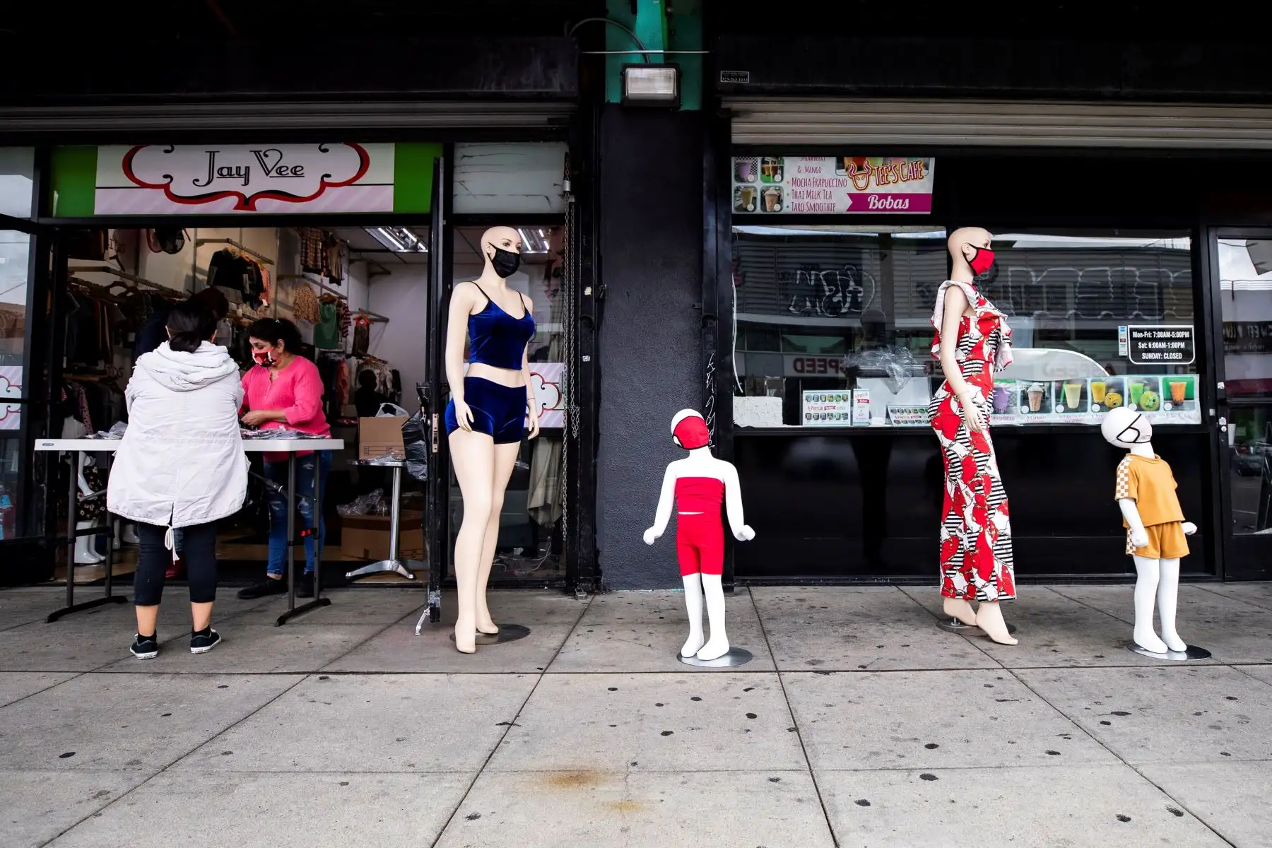 Los Ángeles, Estados Unidos.Una mujer compra máscaras faciales en una tienda rodeada de maniquíes con máscaras de tela en medio de la pandemia de coronavirus en el distrito de la moda en Los Ángeles. Foto: EFE