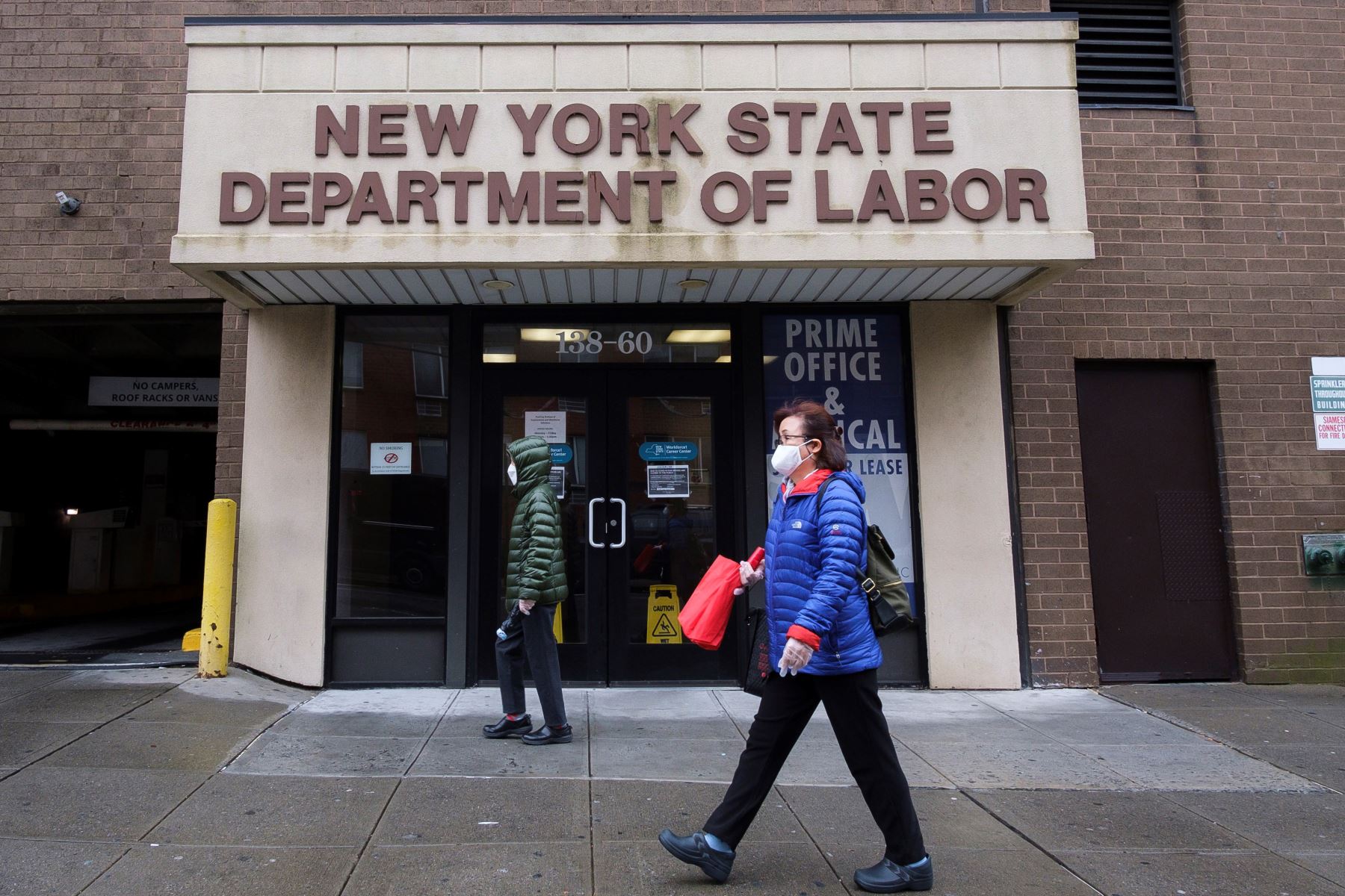 La gente pasa frente a una oficina del Departamento de Trabajo del Estado de Nueva York cerrada debido al coronavirus.
Foto: EFE