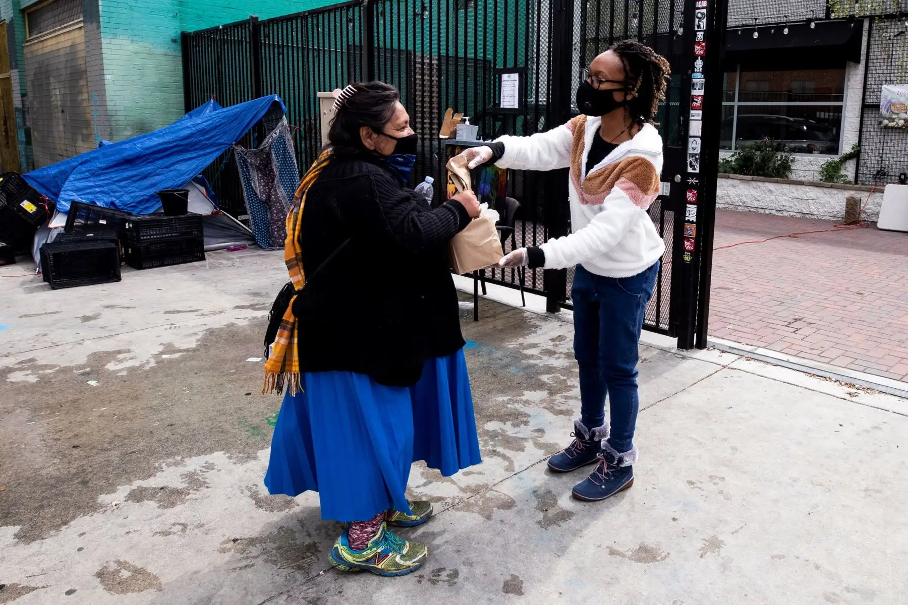Una mujer sin hogar recibe una bolsa de comida de la Red de Acción Comunitaria  cerca de Skid Row en Los Ángeles.
Foto: EFE