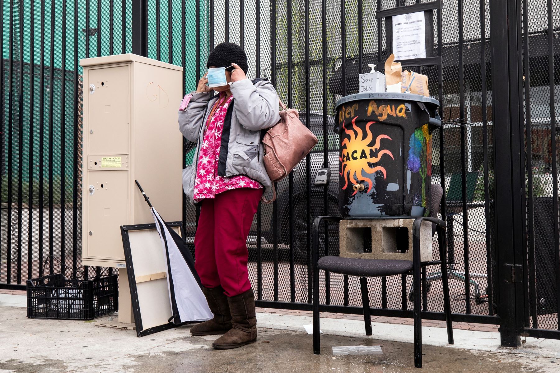 Una mujer sin hogar se pone una máscara quirúrgica, después de lavarse las manos antes de recibir una bolsa de comida de la Red de Acción Comunitaria de Los Ángeles.
Foto: EFE