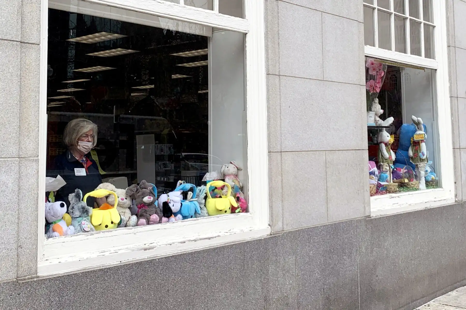 Una empleada de CVS con una máscara facial mira a la calle Boylston durante una exhibición de Pascua  en Boston. 
Foto: AFP