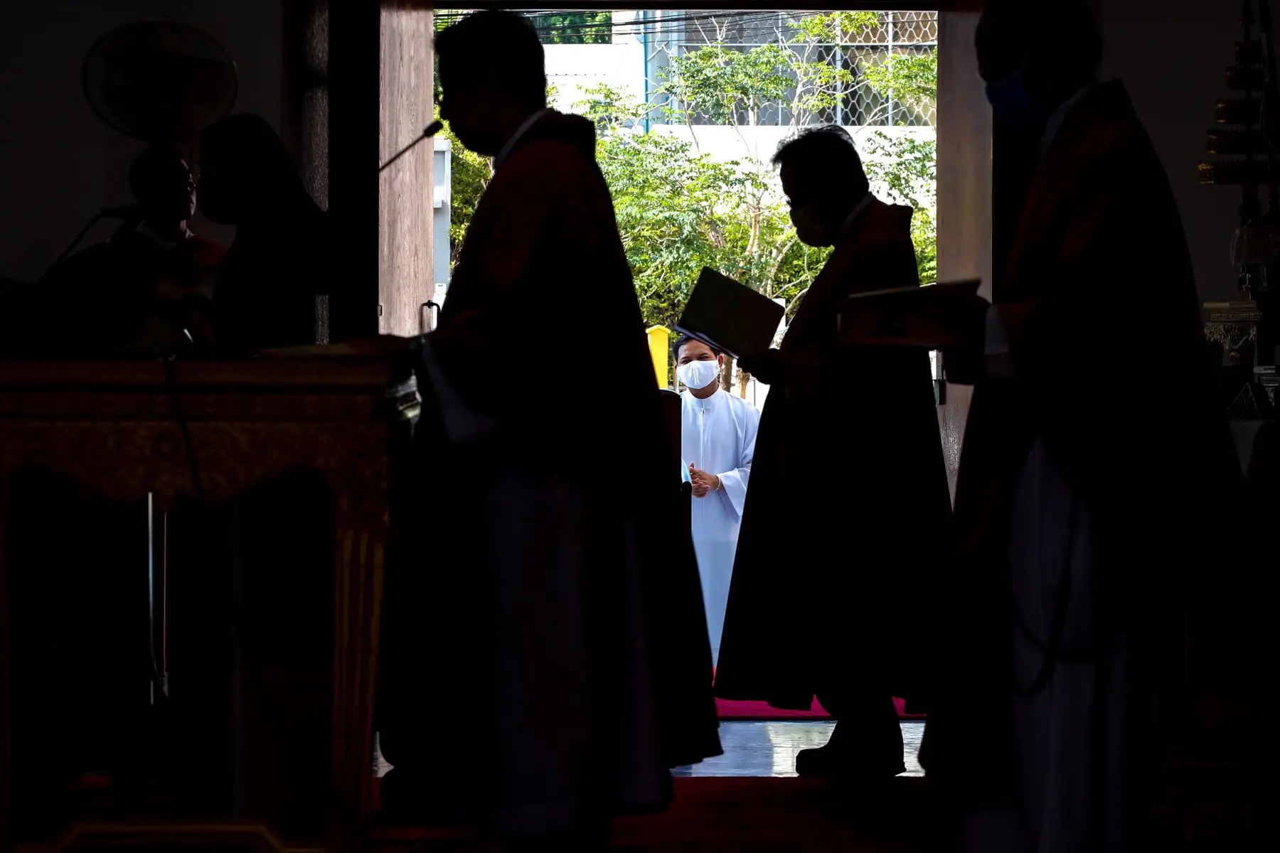 Un sacerdote con máscara protectora observa a sus compañeros sacerdotes dirigir una misa en una iglesia casi vacía el Viernes Santo en Bangkok, Tailandia.
Foto: EFE