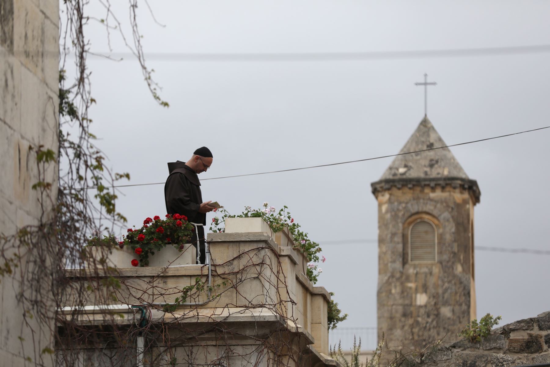 Un monje reza en el tejado de una Iglesia en la Vía de la Rosa durante la procesión del Viernes Santo en la Ciudad Vieja de Jerusalén.
Foto: EFE