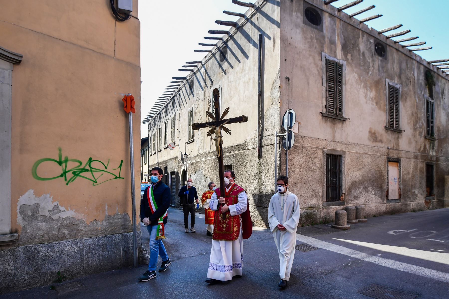 El párroco de la iglesia de Santa Maria Assunta en Pontoglia realiza Vía Crucis con una máscara facial, escoltado por el alcalde de Pontoglio. Foto: AFP