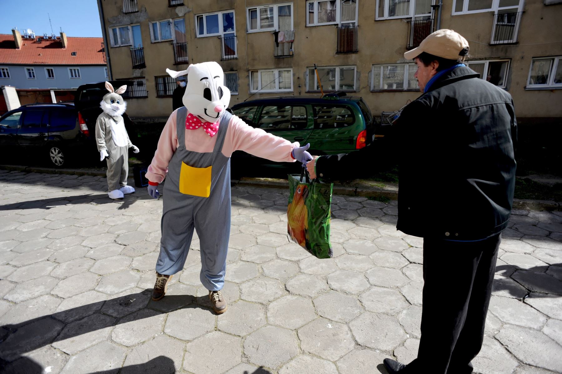 Una persona disfrazada de conejito de Pascua entrega comida de Pascua en Polonia. Foto: EFE