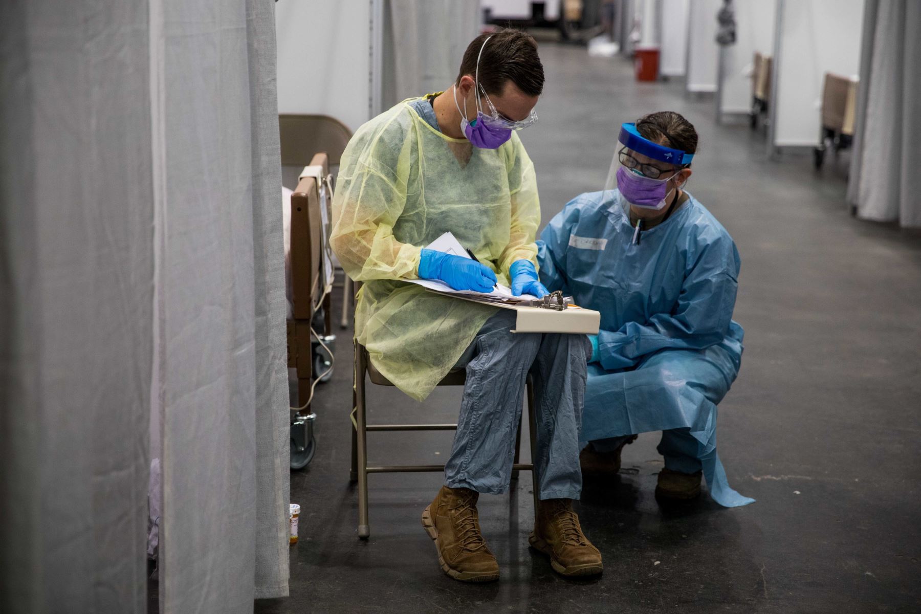 Soldados asignados a la Estación Médica Javits de Nueva York revisando el historial médico de un paciente COVID-19, en la unidad de cuidados intensivos. Foto: EFE
