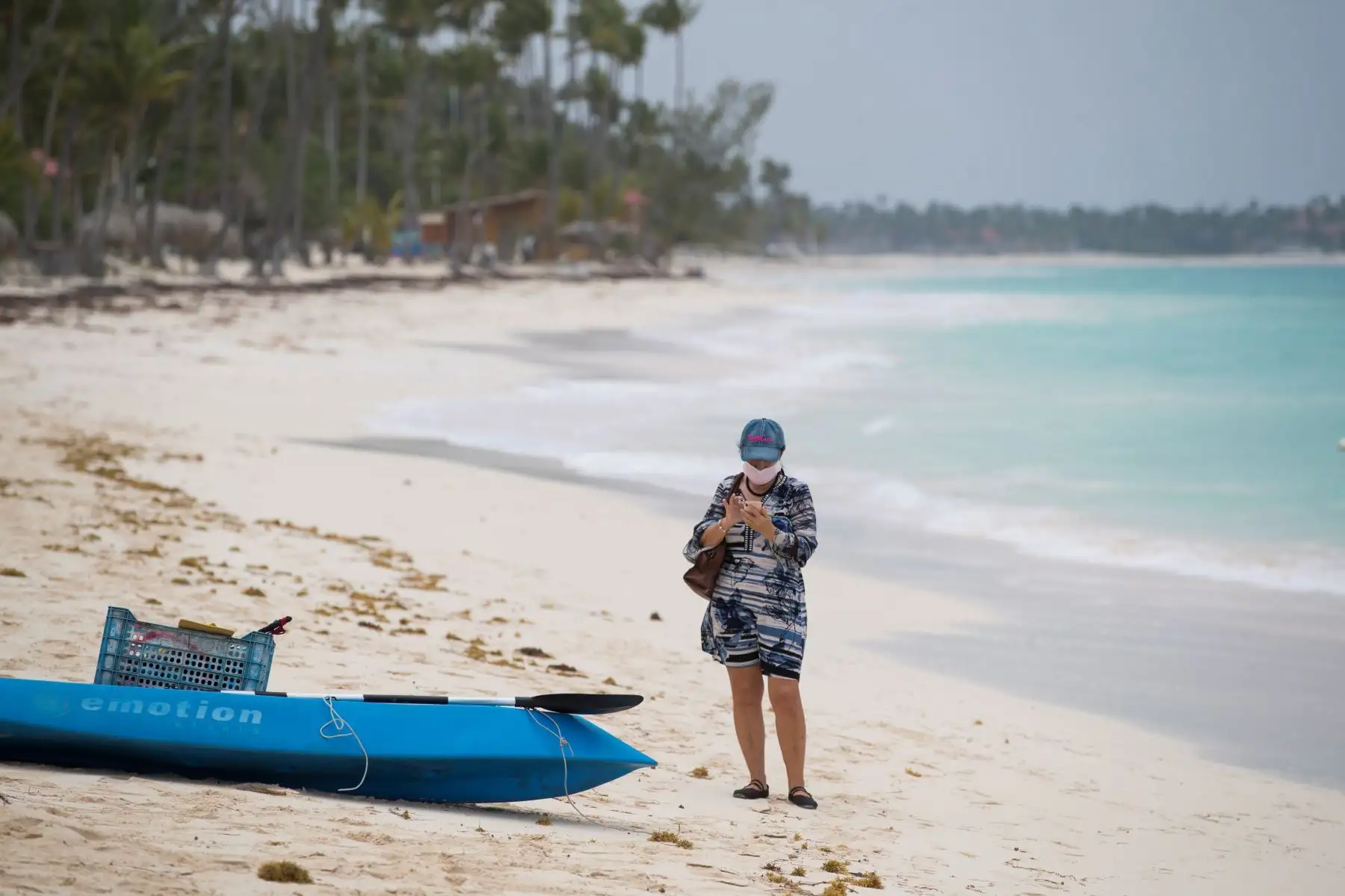 Una mujer protegida con una mascarilla camina por una playa completamente vacía  en Punta Cana. Playas vacías, hoteles cerrados, personas desempleadas, es la desoladora imagen que se repite una y otra vez en la paradisíaca Punta Cana, este de República Dominicana.
Foto: EFE