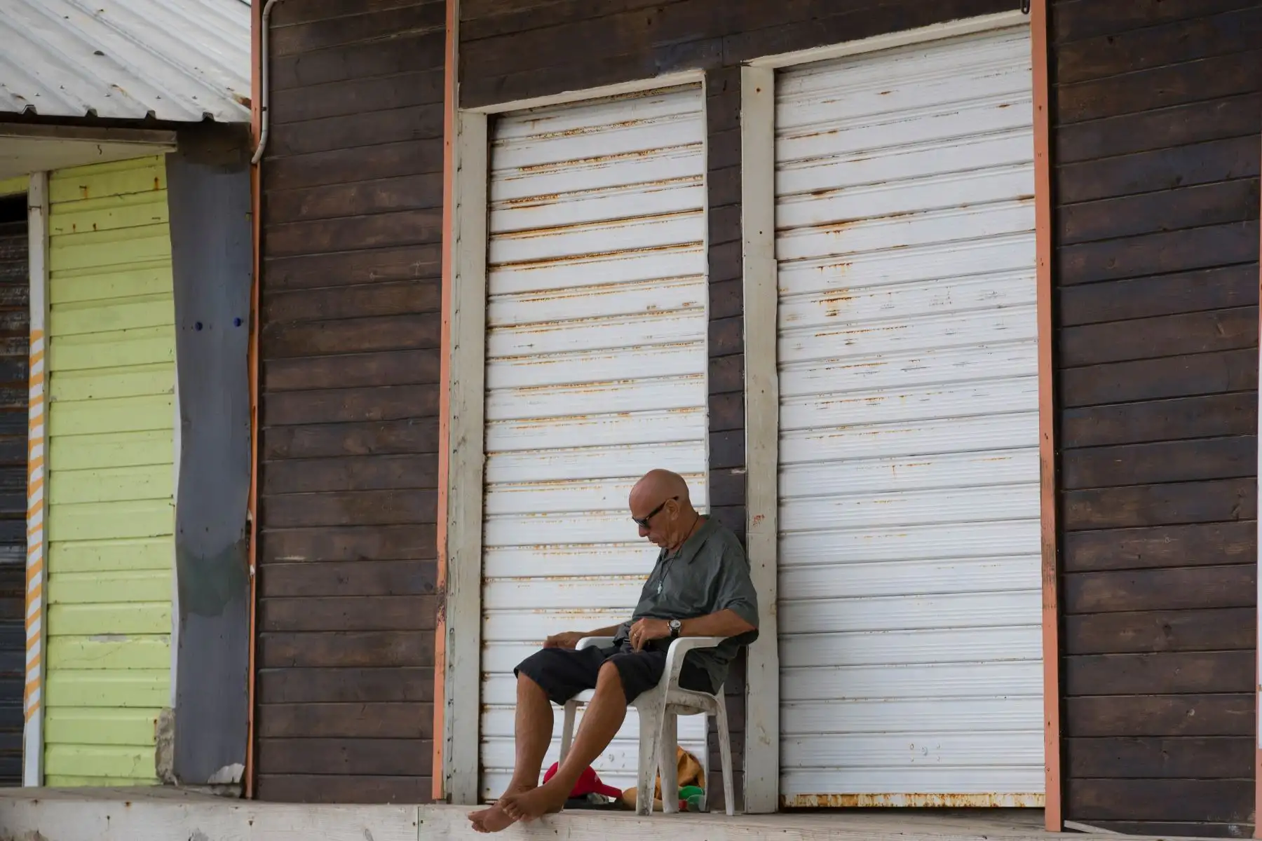 Un hombre descansa frente a varios locales cerrados cerca de las playas de Bávaro en Punta Cana, República Dominicana. 
Foto: EFE
