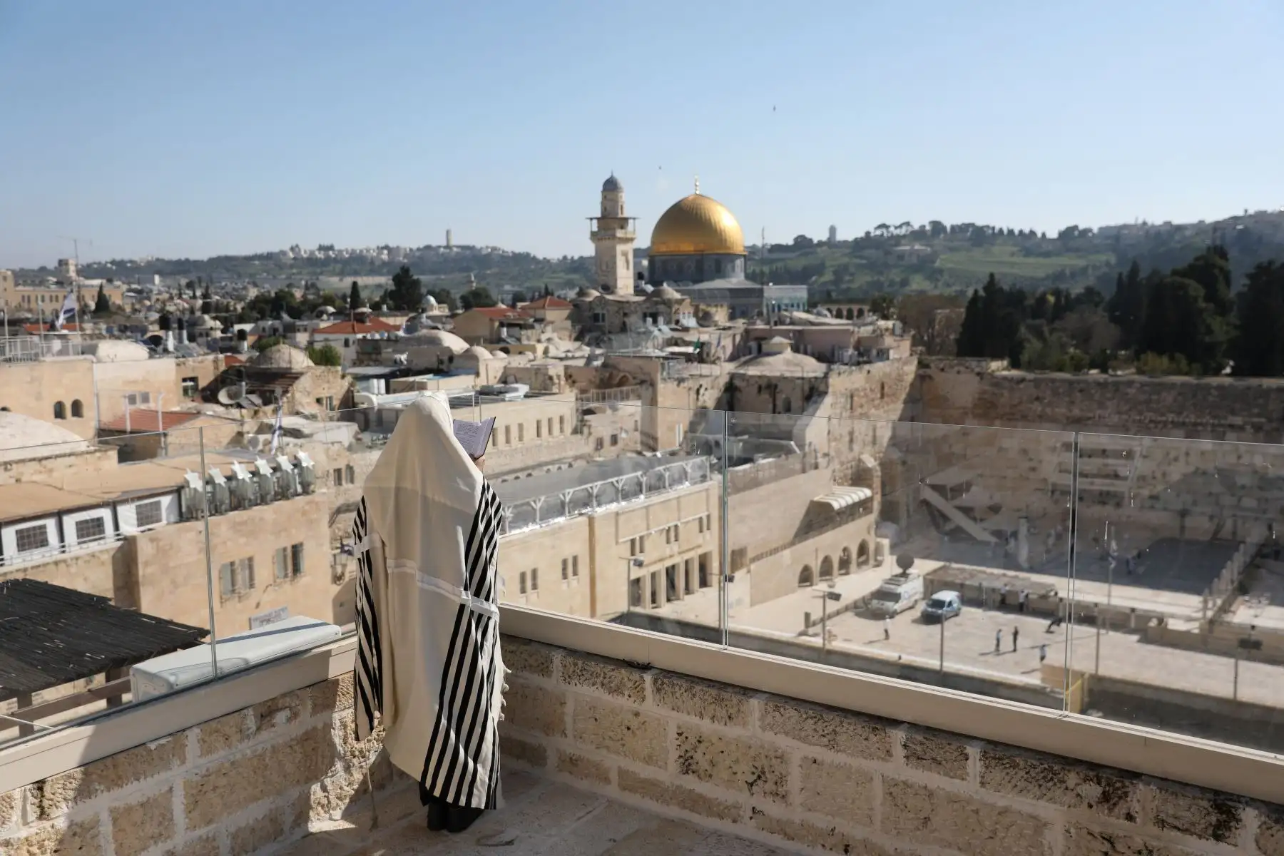 Un hombre judío ortodoxo se cubre con chales de oración mientras recita la Bendición Sacerdotal en la alta festividad de la Pascua en un tejado frente al Muro de los Lamentos, en Jerusalén, Israel.
Foto: EFE