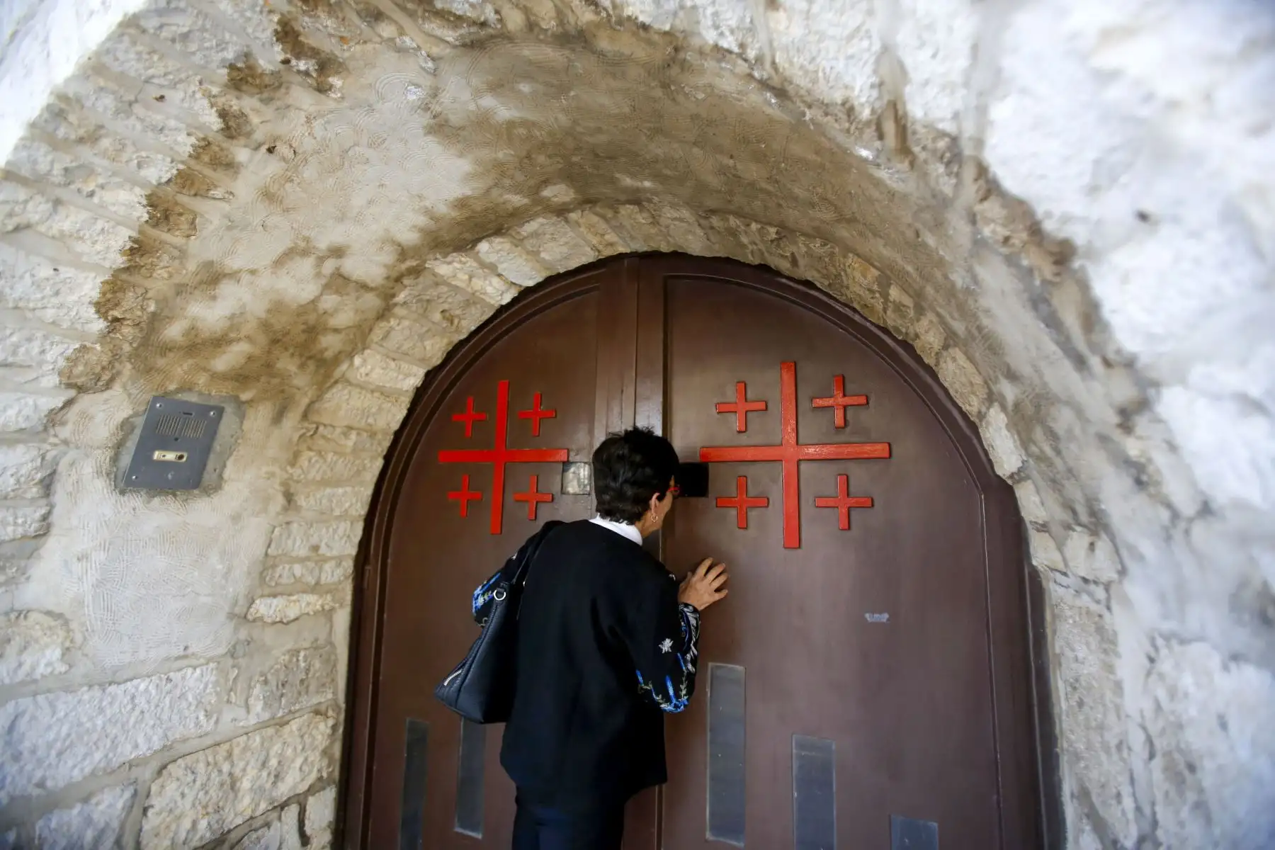 Un creyente cristiano reza en la puerta de la Iglesia de Santa Catalina en el complejo de la Iglesia de la Natividad en la ciudad cisjordana de Belén,durante el servicio del Domingo de Pascua en medio del brote de la enfermedad por coronavirus.
Foto: AFP