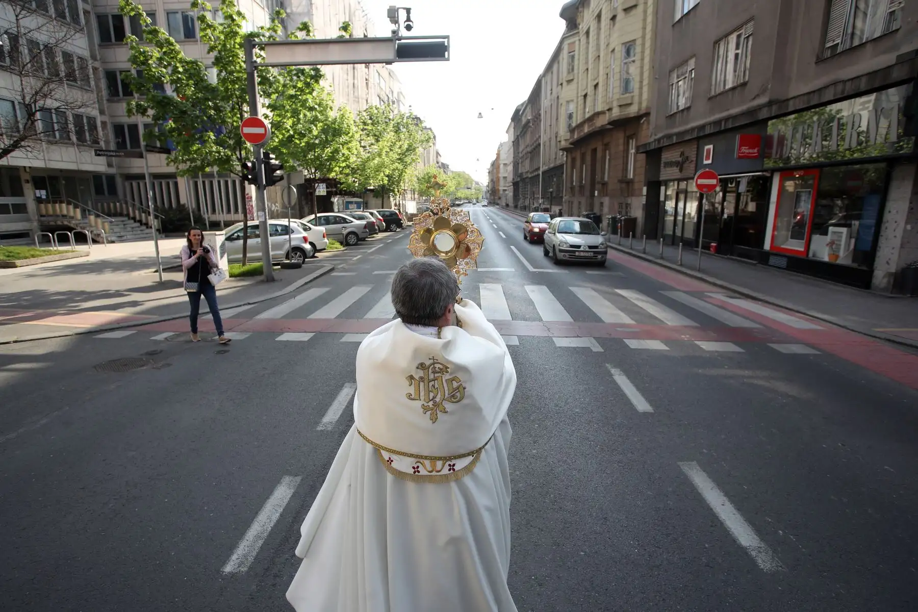 El Pastor Ivan Matic de la Basílica del Sagrado Corazón de Jesús bendice a las personas en las ventanas mientras camina por las calles del centro de Zagreb,  en medio de medidas para evitar la propagación del  coronavirus.
Foto:AFP