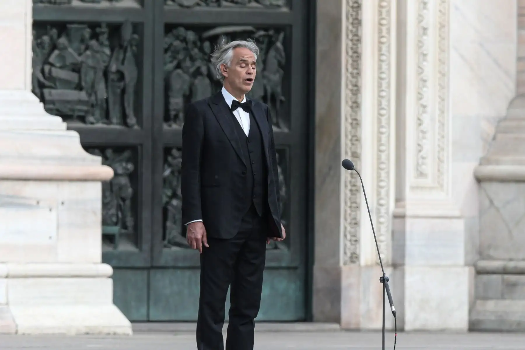 El tenor italiano Andrea Bocelli canta durante un ensayo en una desierta Piazza del Duomo en el centro de Milán, antes de una actuación nocturna sin público para el mundo herido por la pandemia, durante el cierre del país destinado a frenar la propagación de la infección COVID-19. Foto: AFP