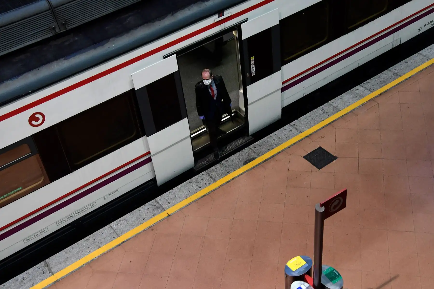 Un hombre con una máscara facial sale de un tren en la estación de Atocha en Madrid, ya que algunas compañías debían reanudar las operaciones al final de dos semanas de detener todas las actividades no esenciales en medio de un cierre nacional a detener la propagación del coronavirus COVID-19.Foto: AFP