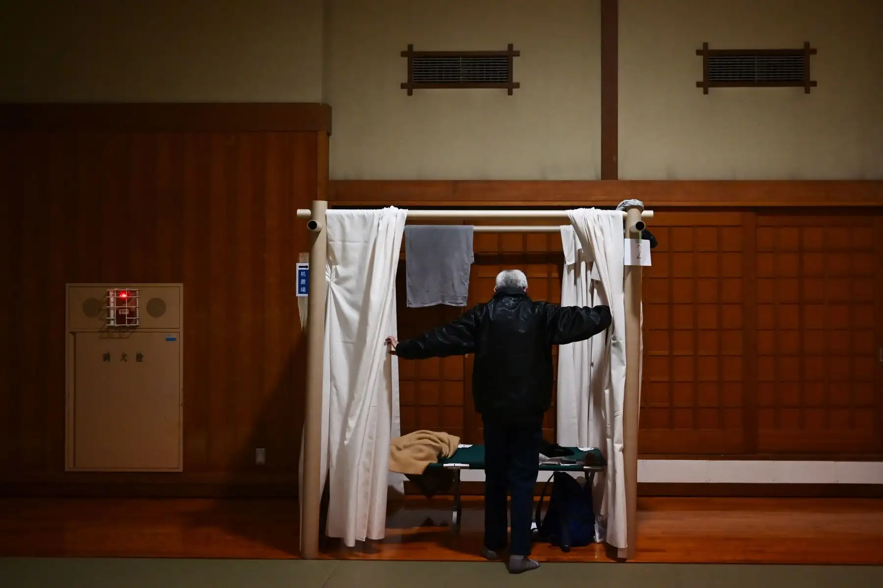 Katsuya Asao, de 54 años, se prepara para descansar en un refugio provisto por la prefectura de Kanagawa para las personas que no pueden pagar el alquiler de un apartamento y solían quedarse en los cibercafés designados, que están cerrados debido al estado de emergencia del brote de coronavirus COVID-19. Una sala de deportes de judo en Yokohama, prefectura de Kanagawa. AFP