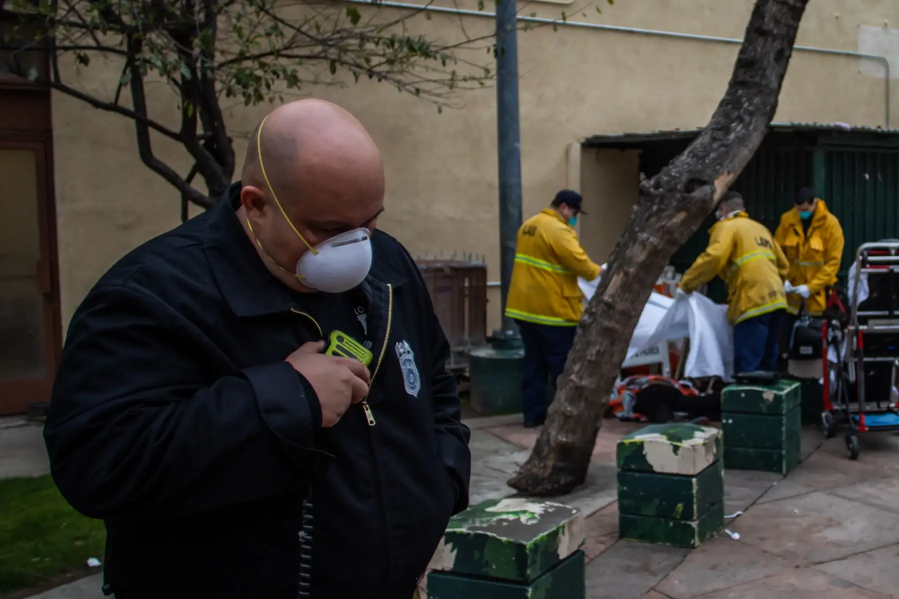 El Capitán Villegas de la Estación LAFD No9 habla en su radio mientras los paramédicos cubren el cuerpo de una mujer sin hogar no identificada que murió por causas desconocidas en Skid Row. AFP