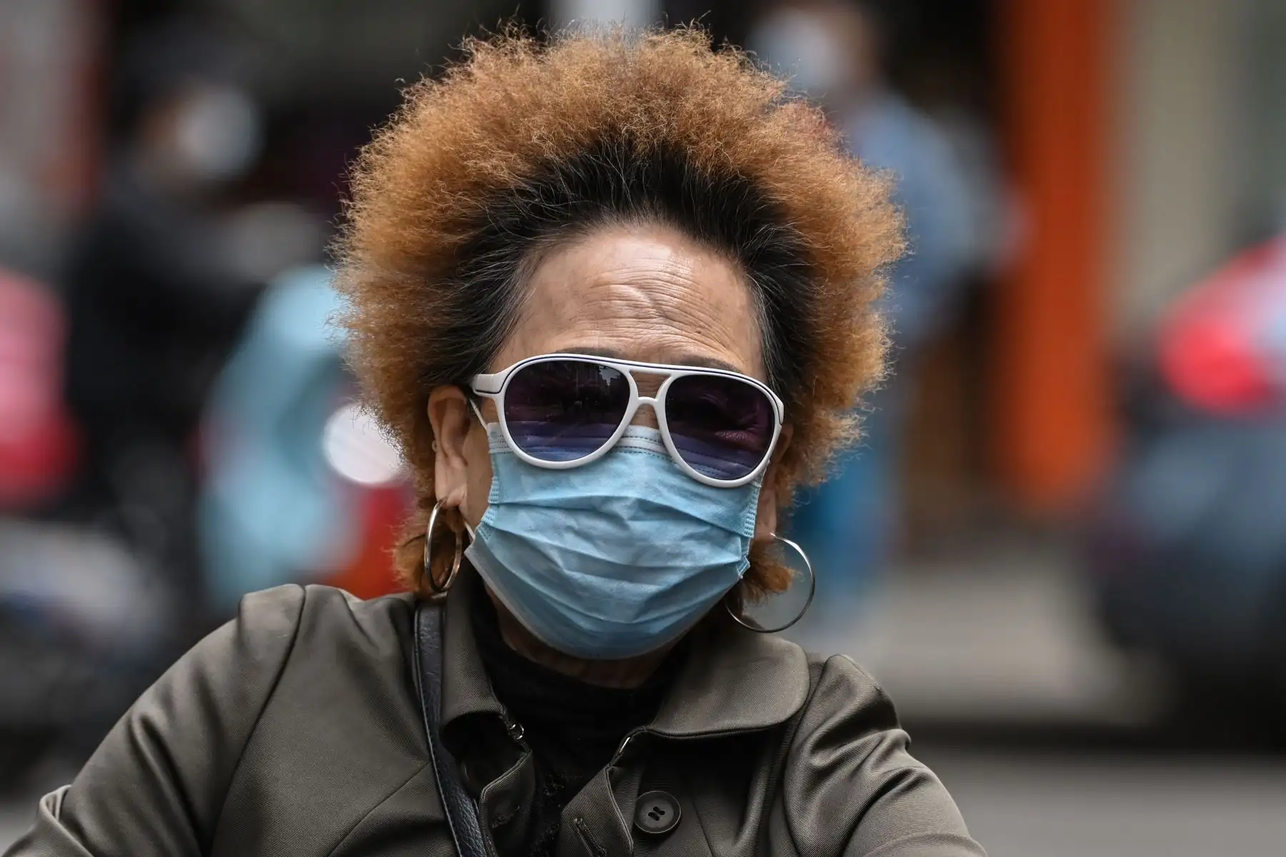 Una mujer con una máscara facial monta un scooter en una calle en Wuhan.
Foto: AFP