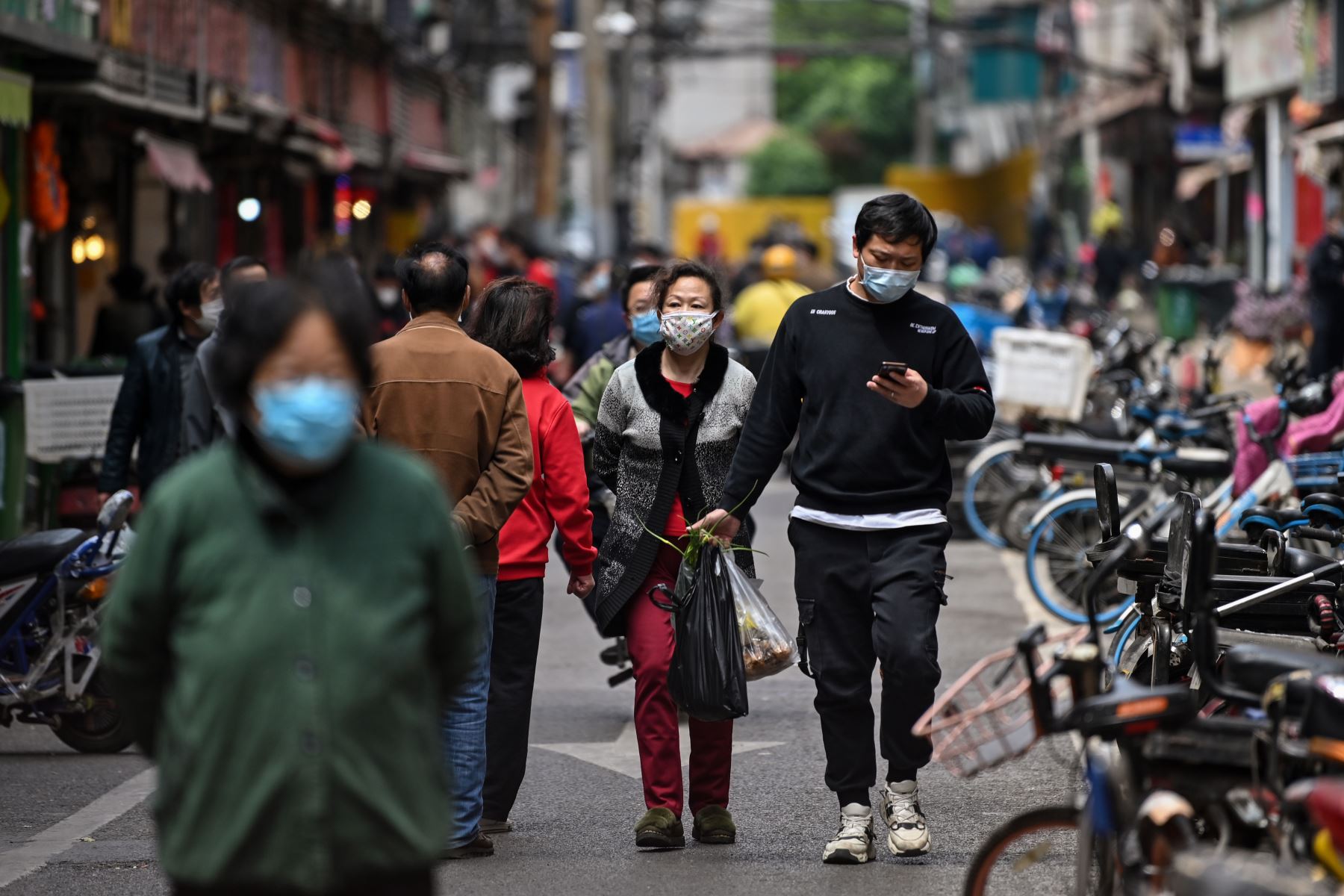 Las personas con máscaras faciales caminan por una calle en Wuhan, la provincia central china de Hubei.
Foto: AFP