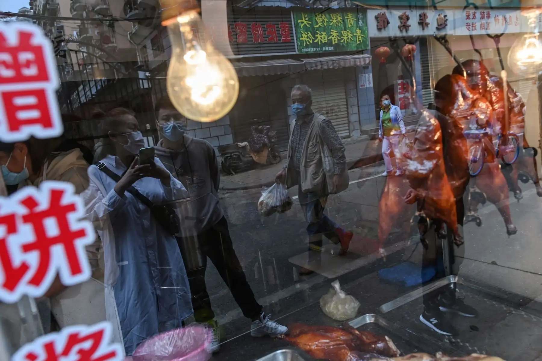 Las personas con máscaras faciales esperan para comprar pato asado en un restaurante en Wuhan.
Foto: AFP