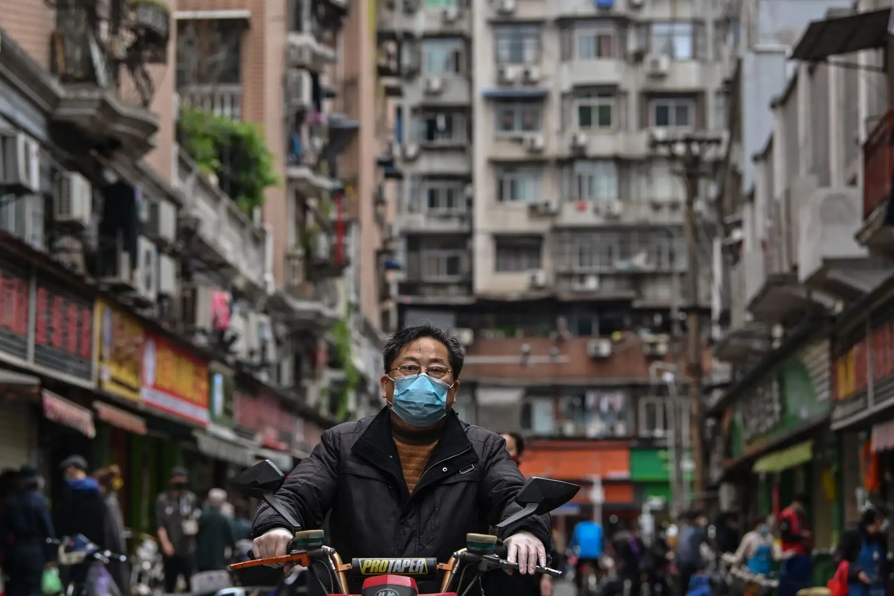 Un hombre que llevaba una máscara facial montaba una moto en una calle de Wuhan, provincia central de Hubei, en China.
Foto: AFP