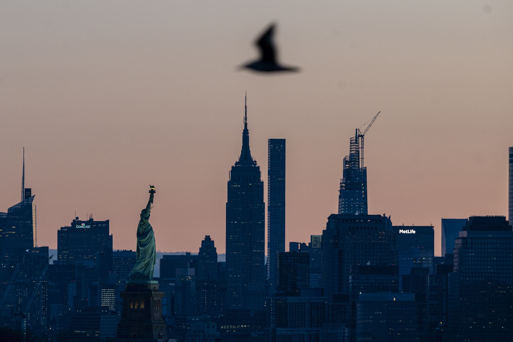El sol sale detrás del horizonte de Manhattan y la Estatua de la Libertad  en la ciudad de Nueva York.
Foto: AFP