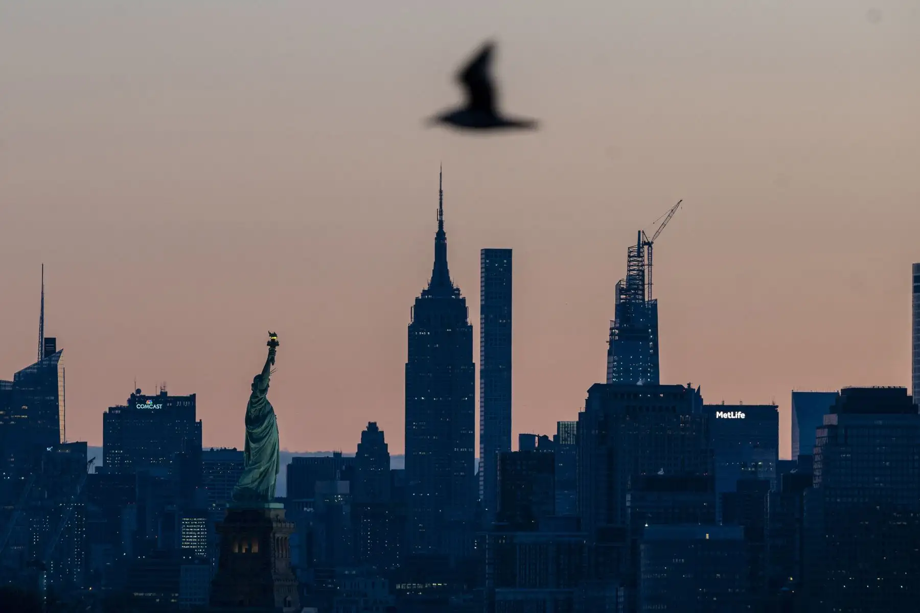 El sol sale detrás del horizonte de Manhattan y la Estatua de la Libertad  en la ciudad de Nueva York.
Foto: AFP