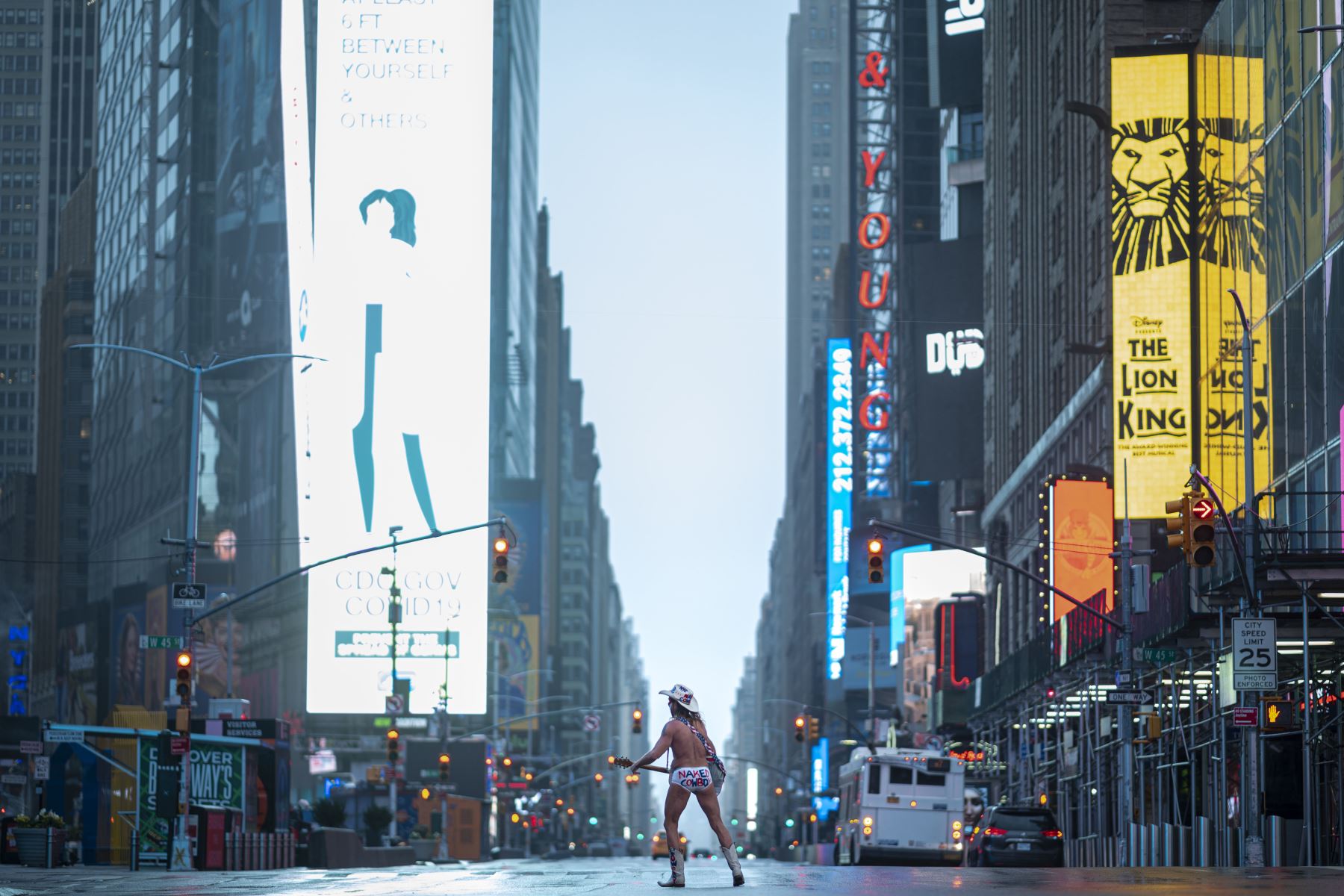 El artista callejero Robert John Burck, conocido como The Naked Cowboy, toca la guitarra en medio de la preocupación por el coronavirus en el casi desierto Times Square de Nueva York. Foto: AFP