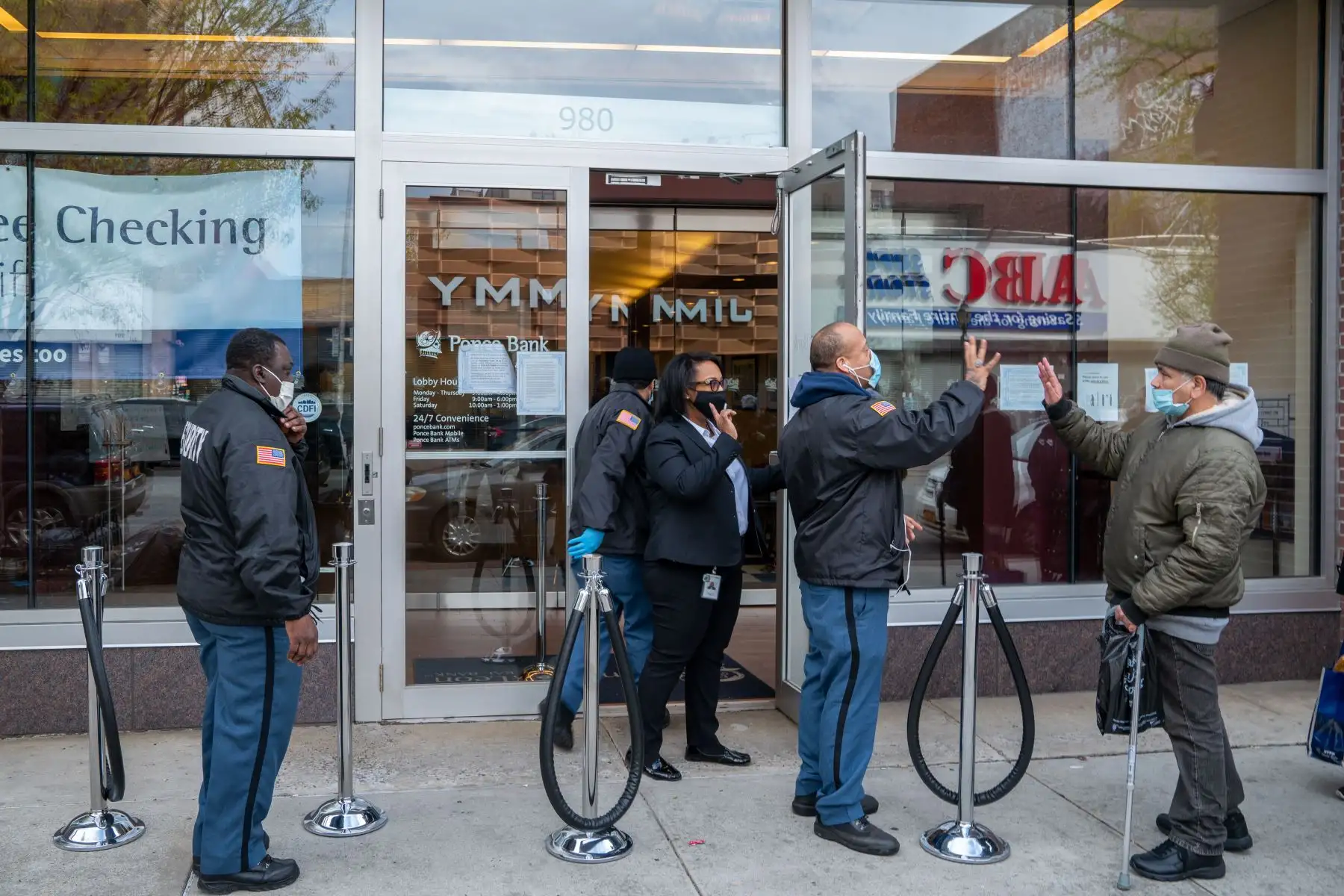 Las personas se saludan mientras hacen cola frente a Ponce Bank en Southern Boulevard  en el distrito de Bronx de la ciudad de Nueva York. 
Foto: AFP