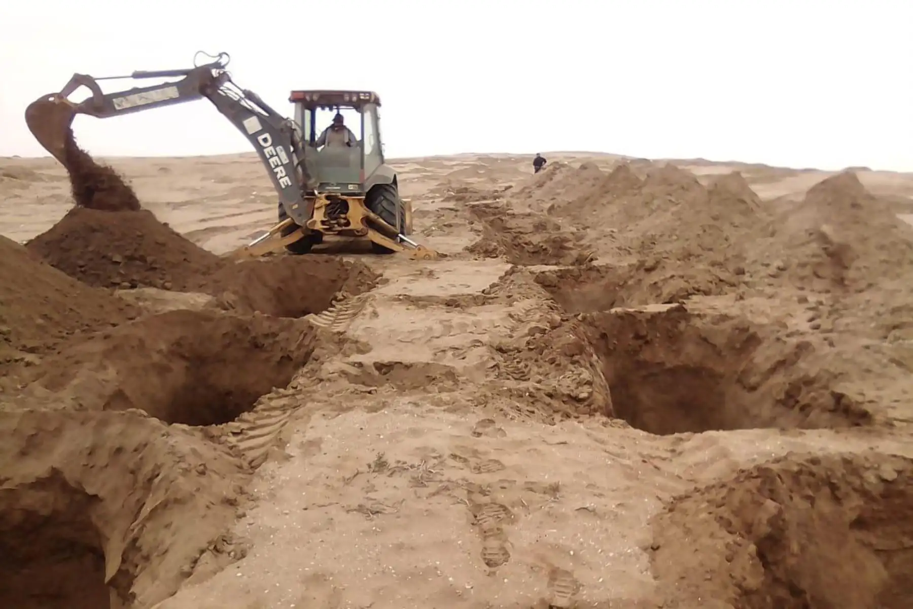 En un cementerio temporal habilitado en la provincia de Lambayeque se construyen fosas individuales para víctimas del coronavirus.