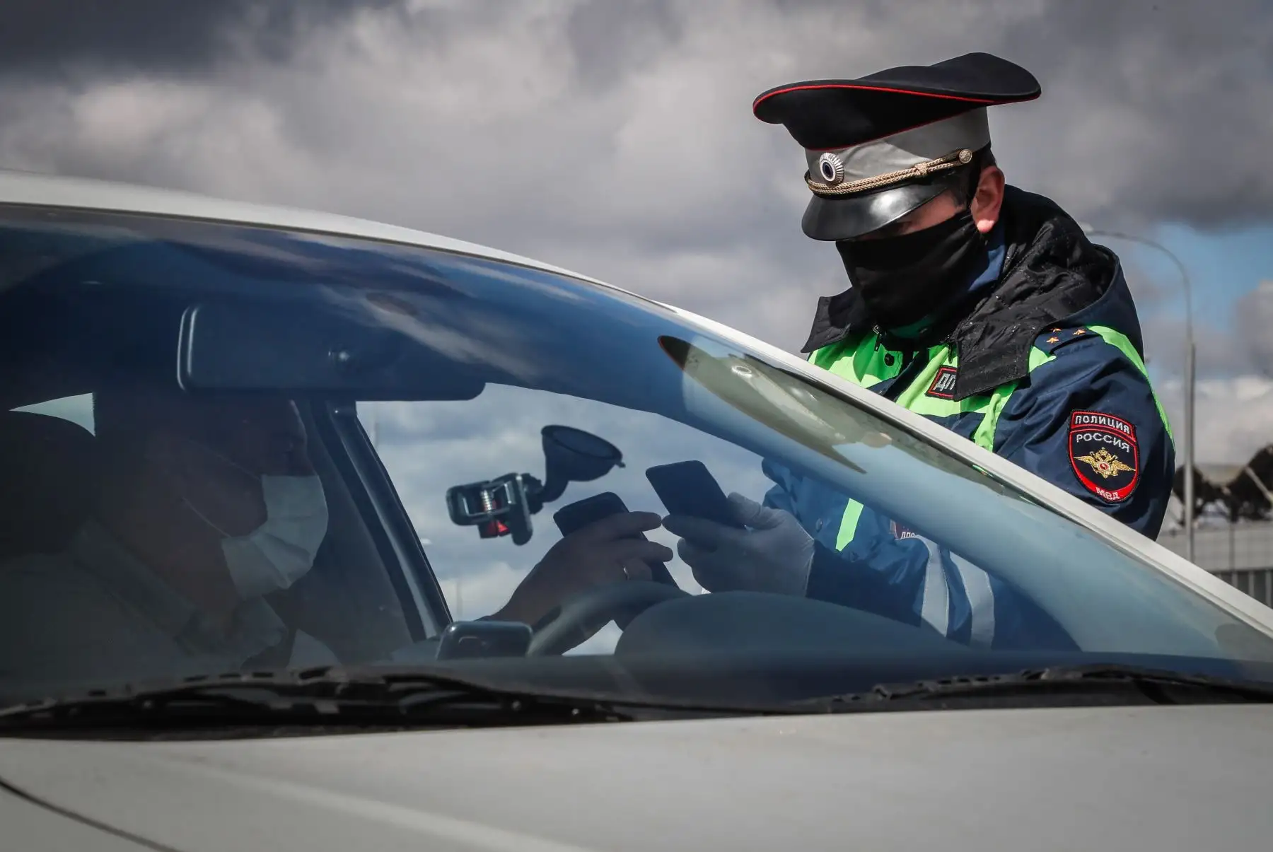 Un oficial de policía ruso verifica las tarjetas de identidad (ID) y los pases de conductores y pasajeros en vehículos que ingresan a la ciudad en un punto de control en Moscú. Foto: EFE