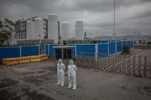 Miembros de seguridad con equipo de protección completo frente a la entrada del Hospital Leishenshan, en Wuhan, China. Foto: EFE