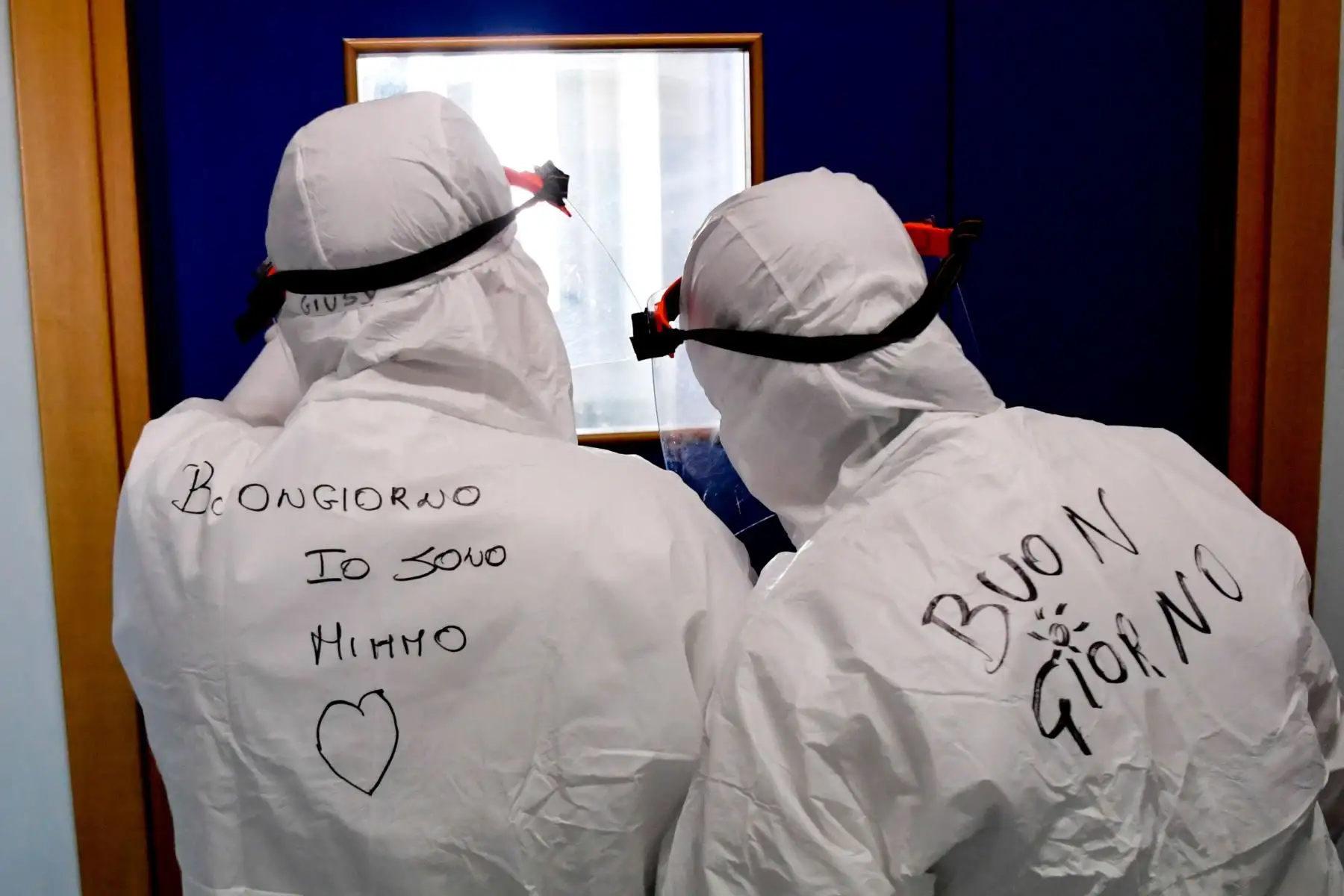 Integrantes del equipo médico observan a un paciente desde el otro lado de la puerta, este miércoles en Nápoles (Italia). Foto: EFE
