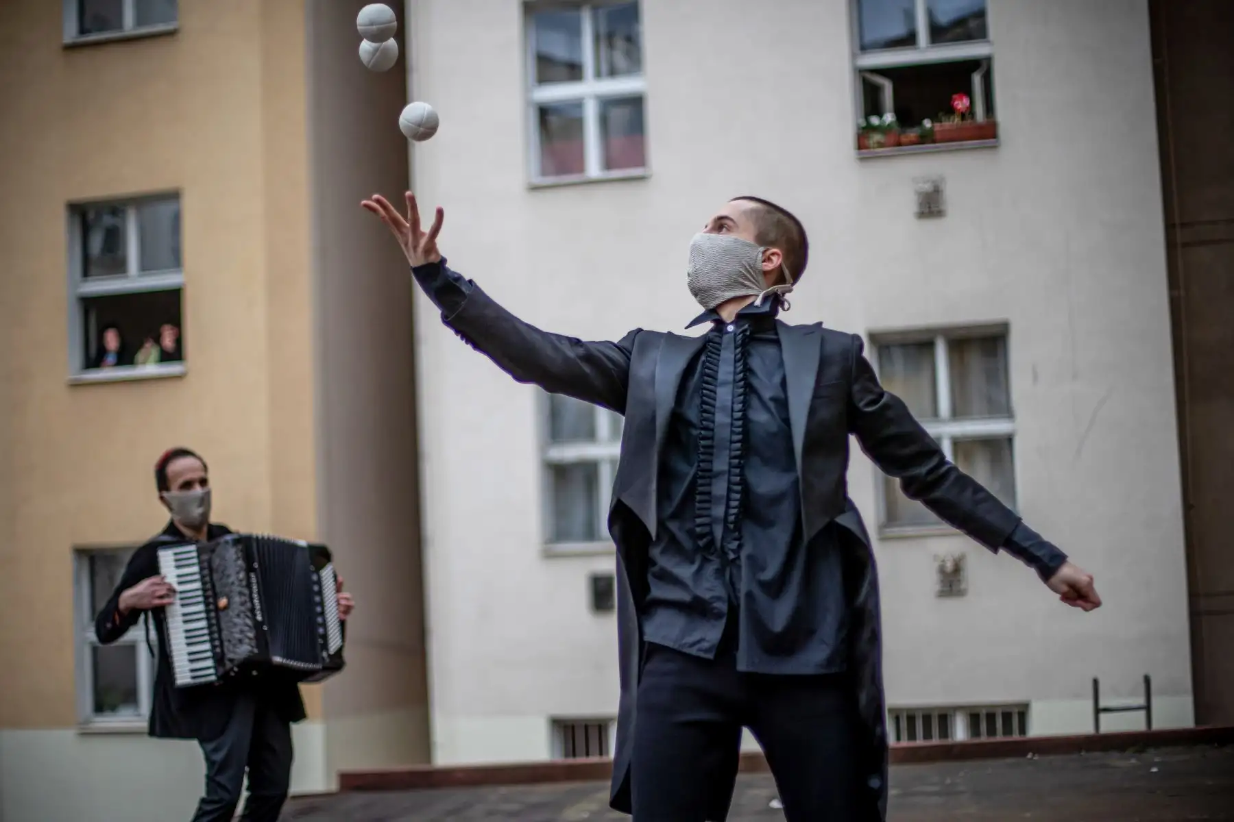 Miembros de la compañía de circo contemporáneo Cirk La Putyka actúan en un patio para entretener a los residentes locales en Praga, República Checa. El objetivo de los eventos de Cirk La Putyka en las calles de la capital checa es brindar arte en vivo a las personas durante el encierro en medio de la pandemia del coronavirus COVID-19. Foto: EFE
