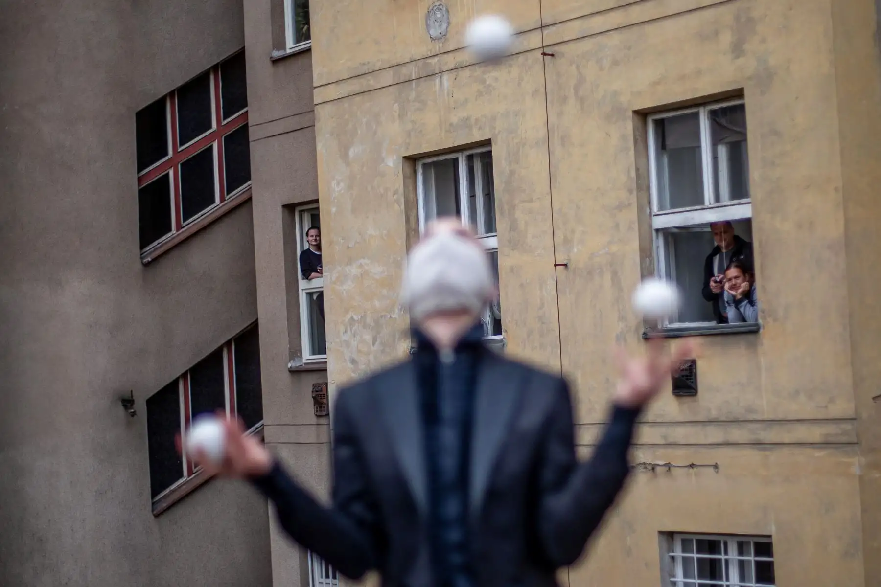 Miembros de la compañía de circo contemporáneo Cirk La Putyka actúan en un patio para entretener a los residentes locales en Praga, República Checa. El objetivo de los eventos de Cirk La Putyka en las calles de la capital checa es brindar arte en vivo a las personas durante el encierro en medio de la pandemia del coronavirus COVID-19. Foto: EFE