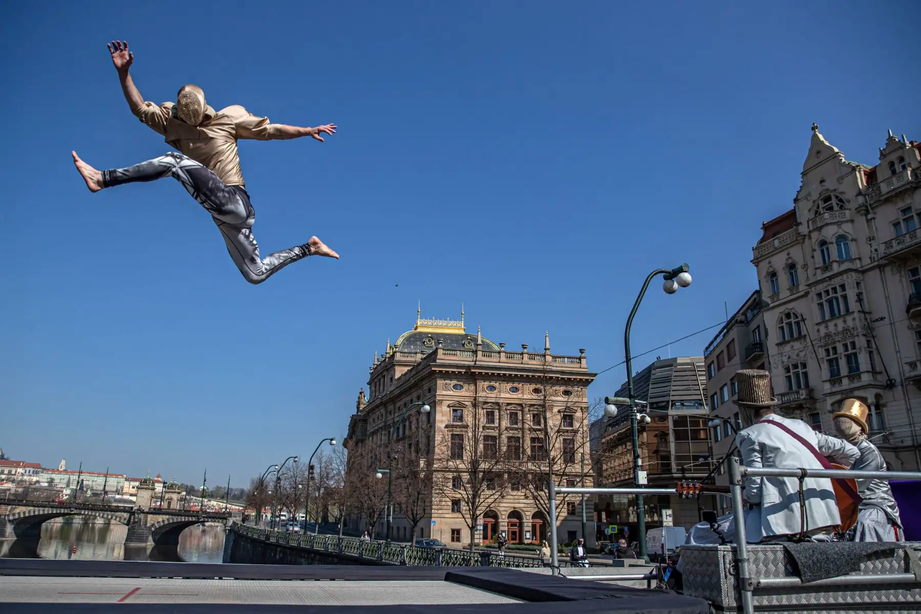 Miembros de la compañía de circo contemporáneo Cirk La Putyka actúan en un patio para entretener a los residentes locales en Praga, República Checa. El objetivo de los eventos de Cirk La Putyka en las calles de la capital checa es brindar arte en vivo a las personas durante el encierro en medio de la pandemia del coronavirus COVID-19. Foto: EFE