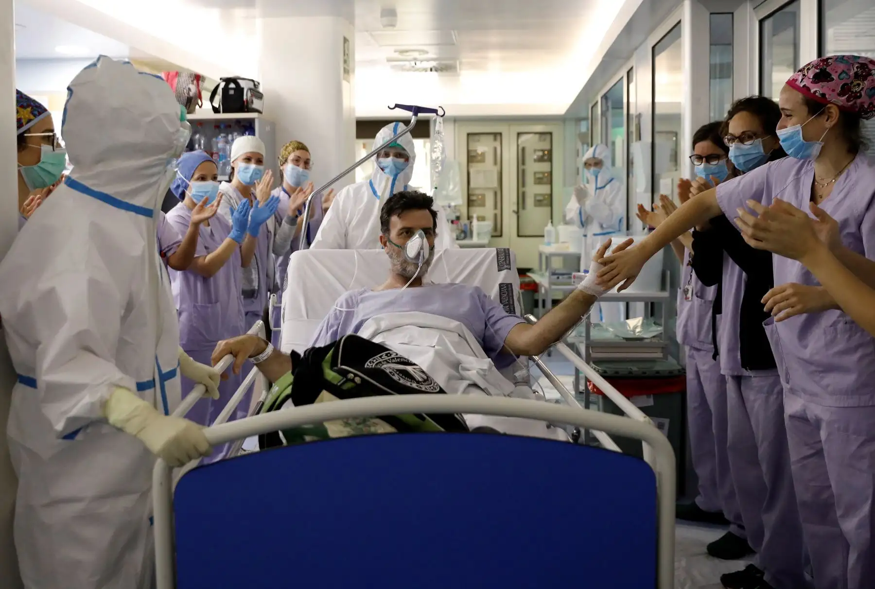 Carlos, de 48 años y paciente durante más de tres semanas, sale de la Unidad de Cuidados intensivos del hospital Clínico de Valencia, feliz y aplaudido por los sanitarios que le han cuidado. Foto: EFE