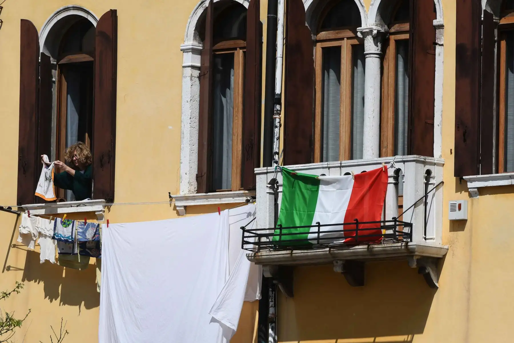 Una mujer cuelga ropa en Venecia el 17 de abril de 2020, mientras la nación busca frenar la propagación de la epidemia de COVID-19 causada por el nuevo coronavirus. Foto: AFP
