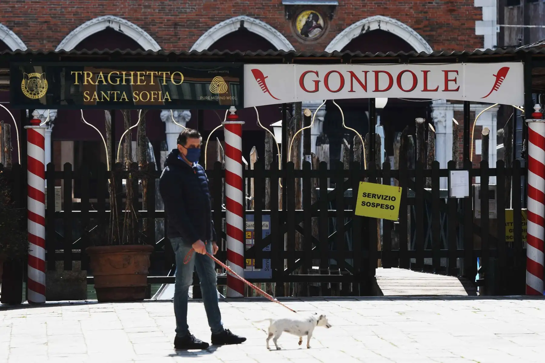 Un hombre pasea a su perro frente al muelle cerrado del ferry en Venecia el 17 de abril de 2020, mientras la nación intenta frenar la propagación de la epidemia COVID-19 causada por el nuevo coronavirus. Foto: AFP
