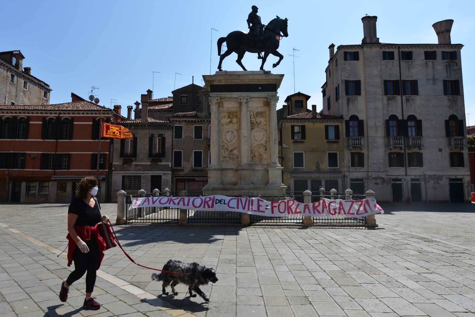 Una mujer pasea a su perro en Campo San Giovanni en Venecia el 17 de abril de 2020, mientras la nación intenta frenar la propagación de la epidemia COVID-19 causada por el nuevo coronavirus. Foto: AFP