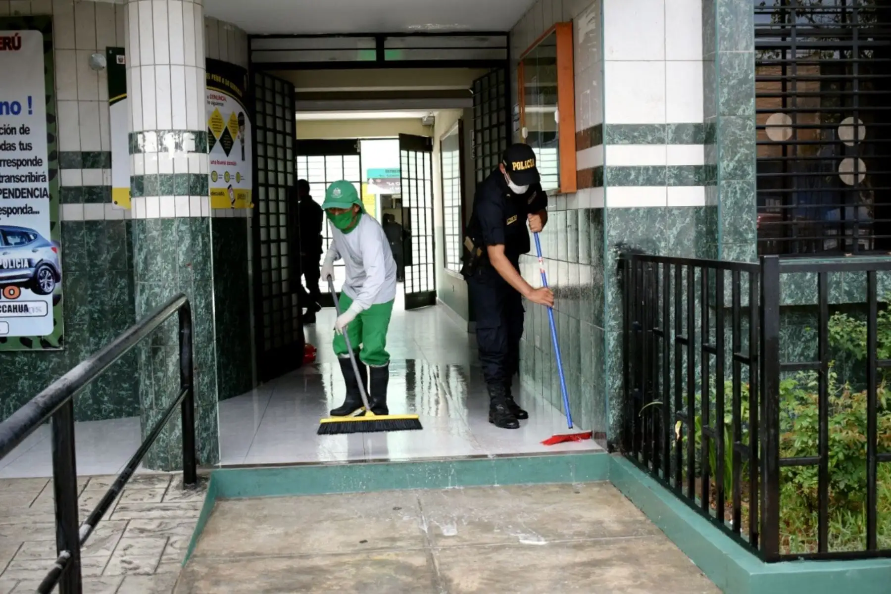 Personal de limpieza de la Municipalidad de San Juan de Lurigancho y efectivo de PNP desinfectan juntos frontis de la dependencia policial. Foto: ANDINA/Municipalidad de San Juan de Lurigancho