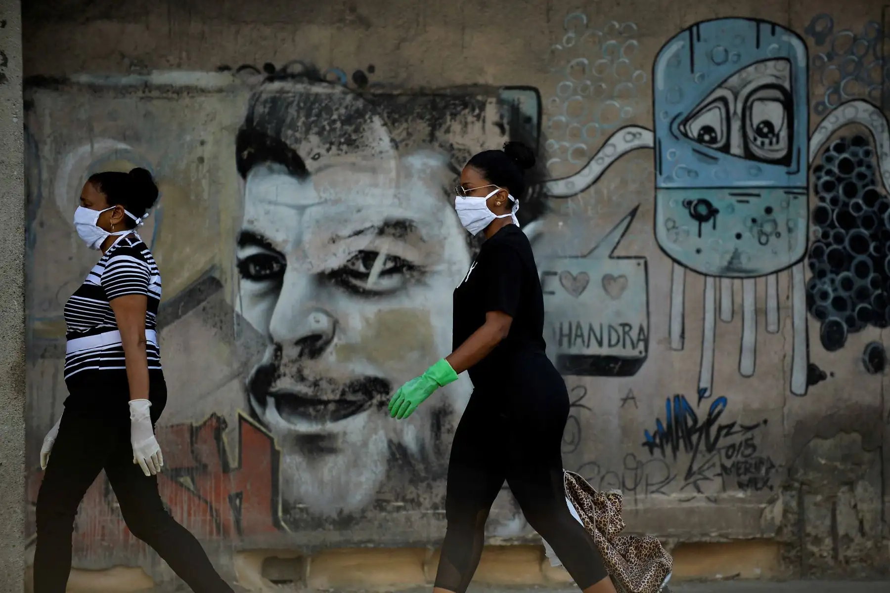 Mujeres con mascarillas y guantes caminan por una calle de La Habana, el 11 de abril de 2020. La isla comunista de un solo partido está teniendo dificultades para obtener suministros médicos. Foto: AFP