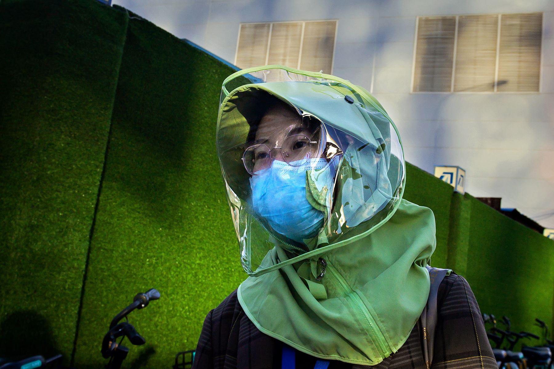 Una mujer con una máscara facial y una máscara de ropa de diseño en medio de las preocupaciones sobre el coronavirus COVID-19 camina por una calle en Beijing. Foto: AFP